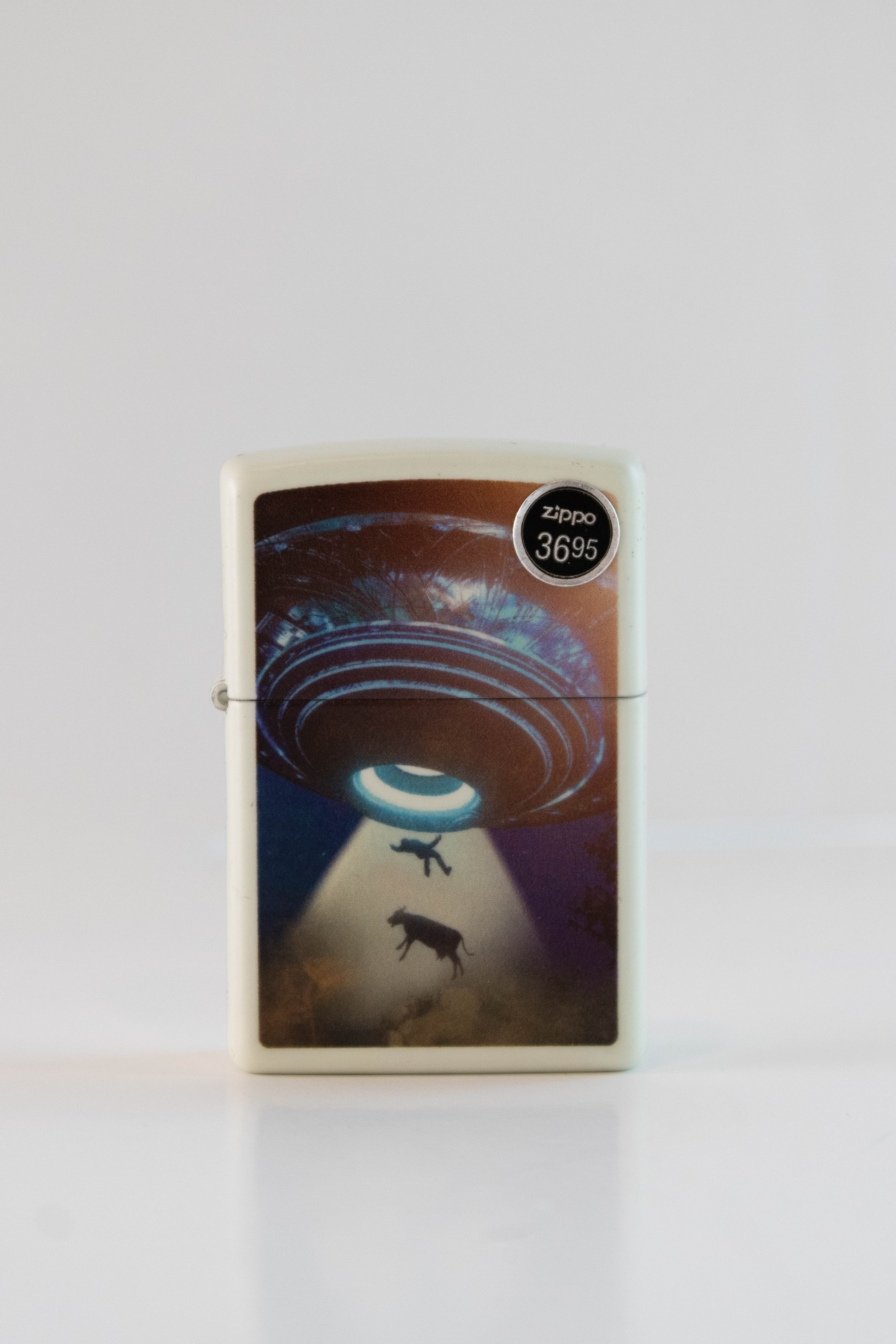 Zippo lighter featuring UFO abduction scene artwork