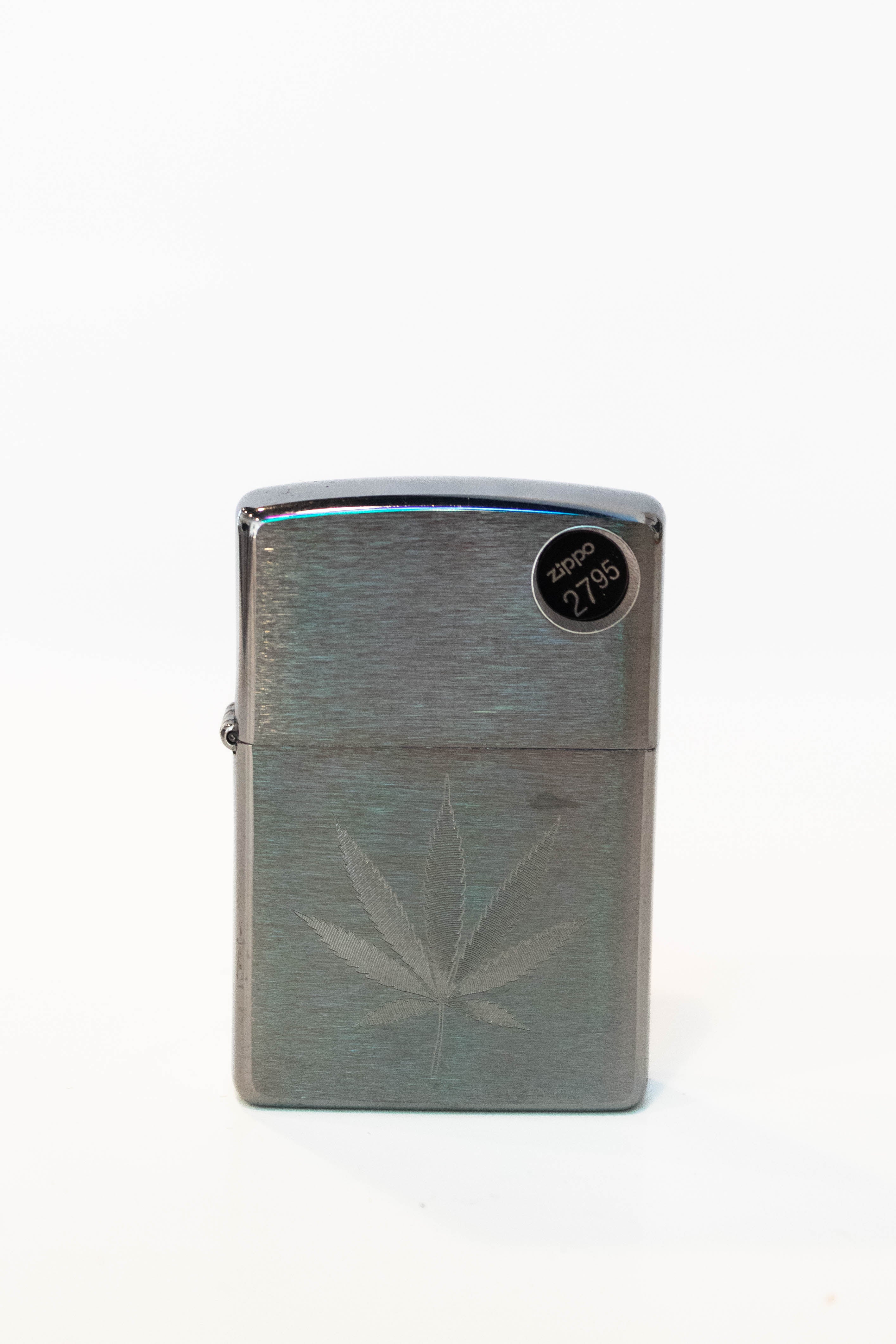 Zippo lighter with engraved cannabis leaf design on metal case