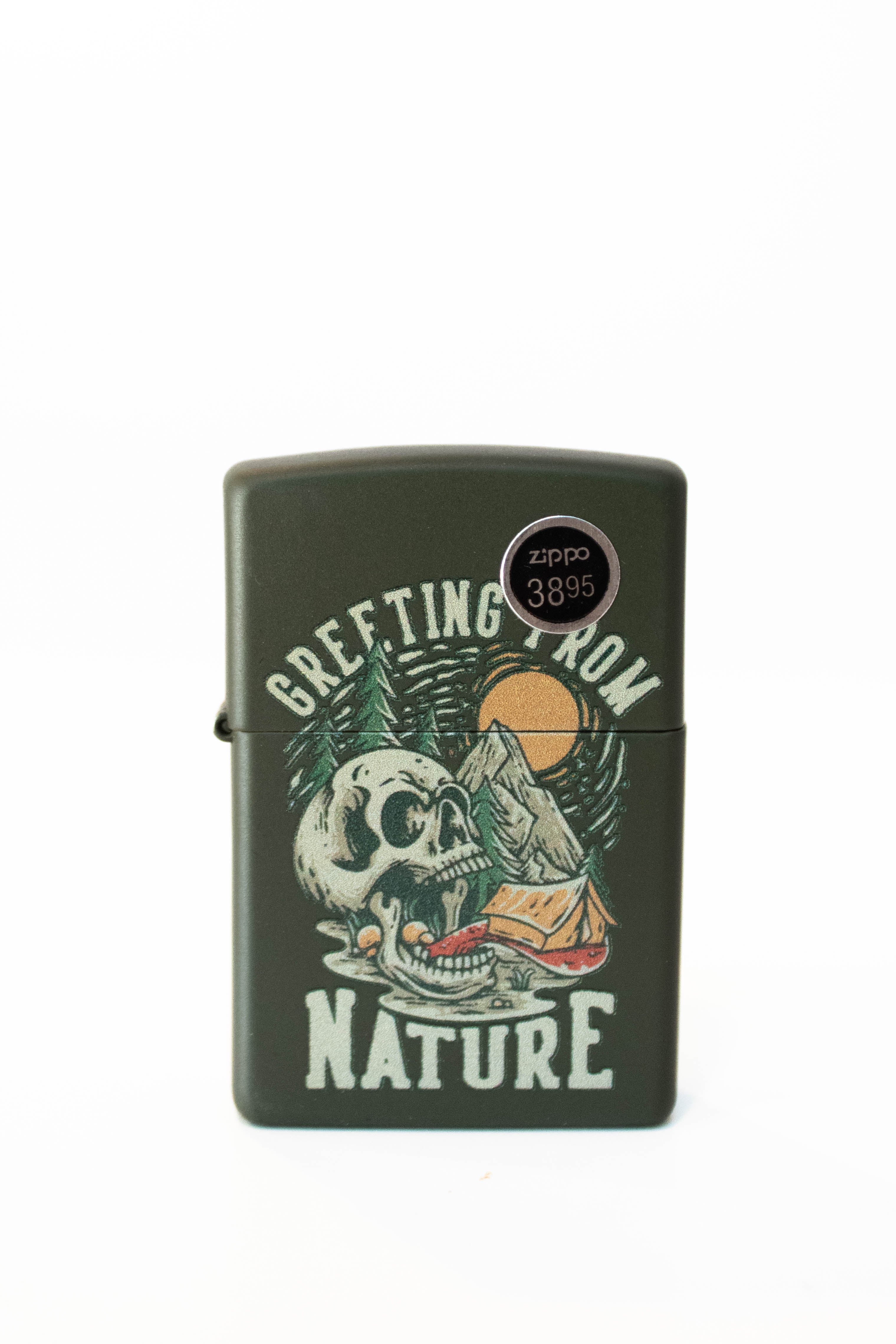 Zippo lighter featuring skull and nature themed artwork